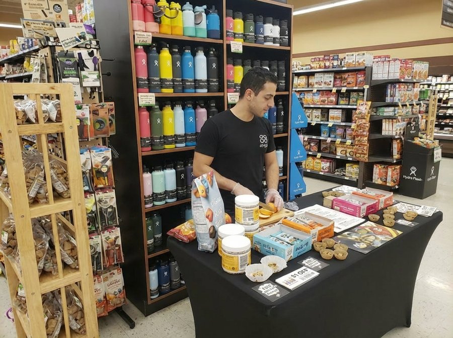 Ambassador handing sample